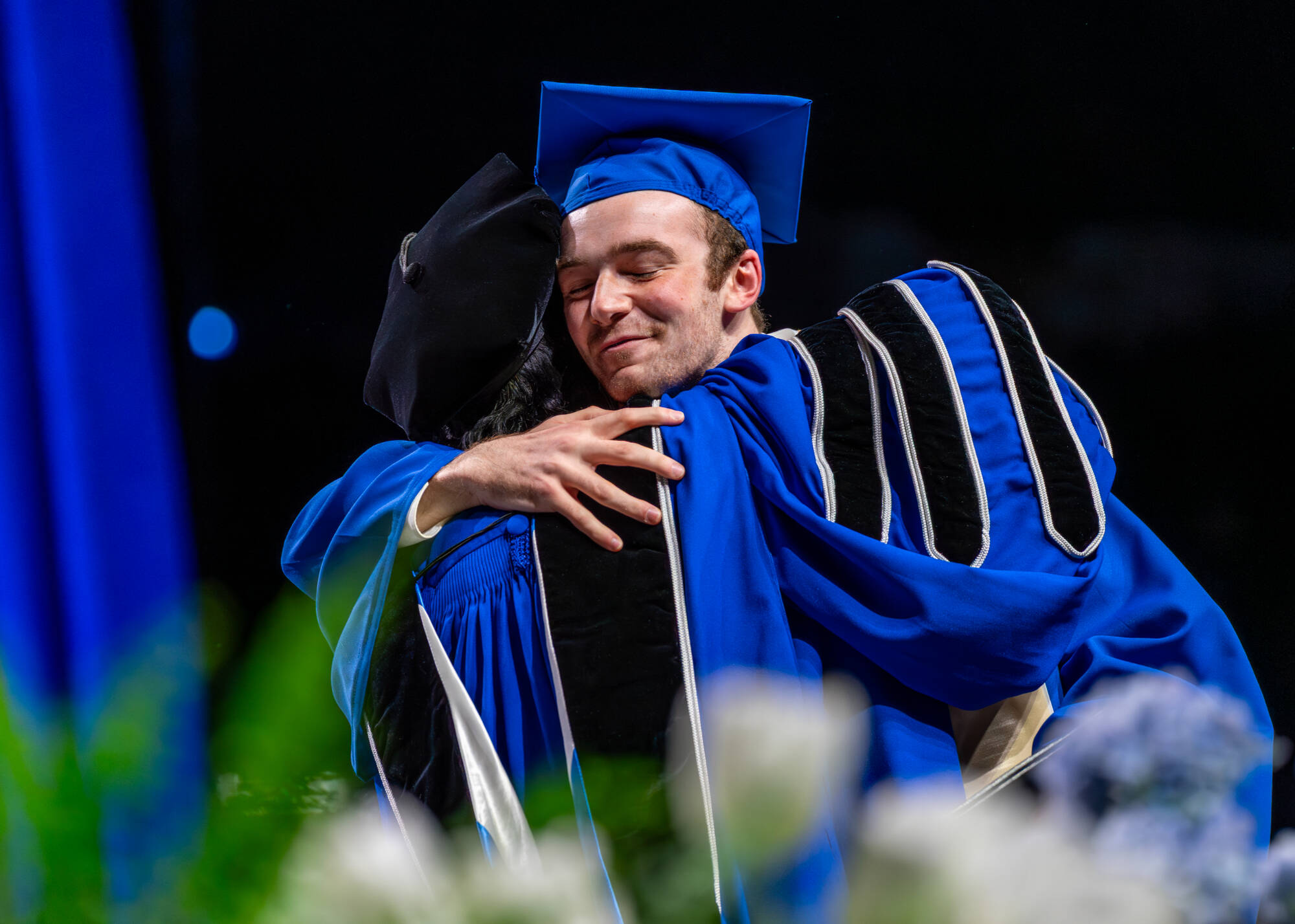 Student Senate President Quinten D. Proctor hugs President Philomena V. Mantella during the Commencement ceremony at Van Andel Arena on April 26.